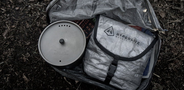 A backpack with a stove, pot, and utensils.