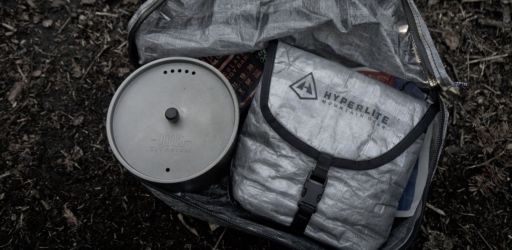 A backpack with a pot, pan, and utensils in it.