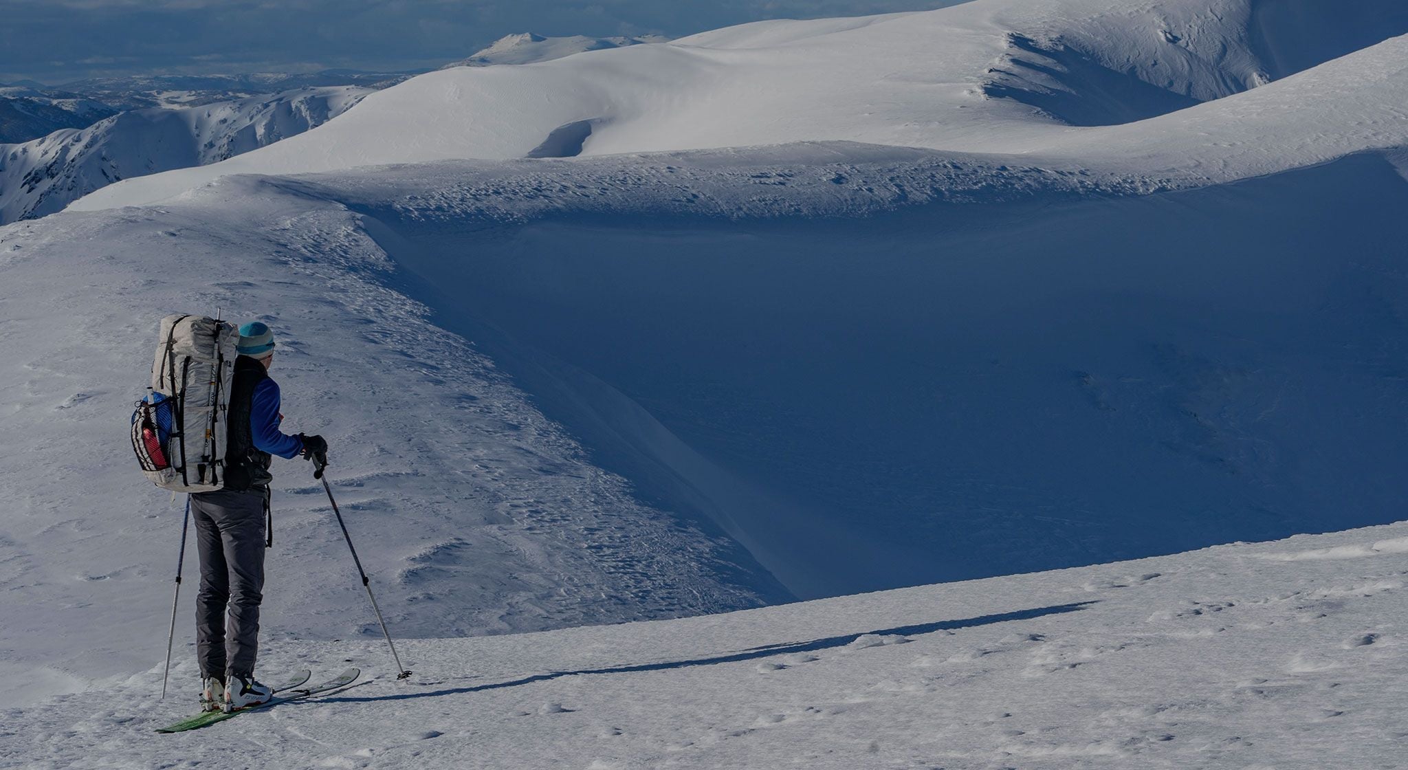 A person on skis standing on top of a snow covered mountain.