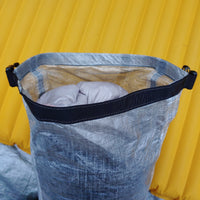 A sleeping bag sitting on top of a yellow tarp.
