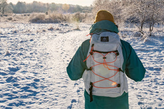 A person walking through the snow with a backpack.