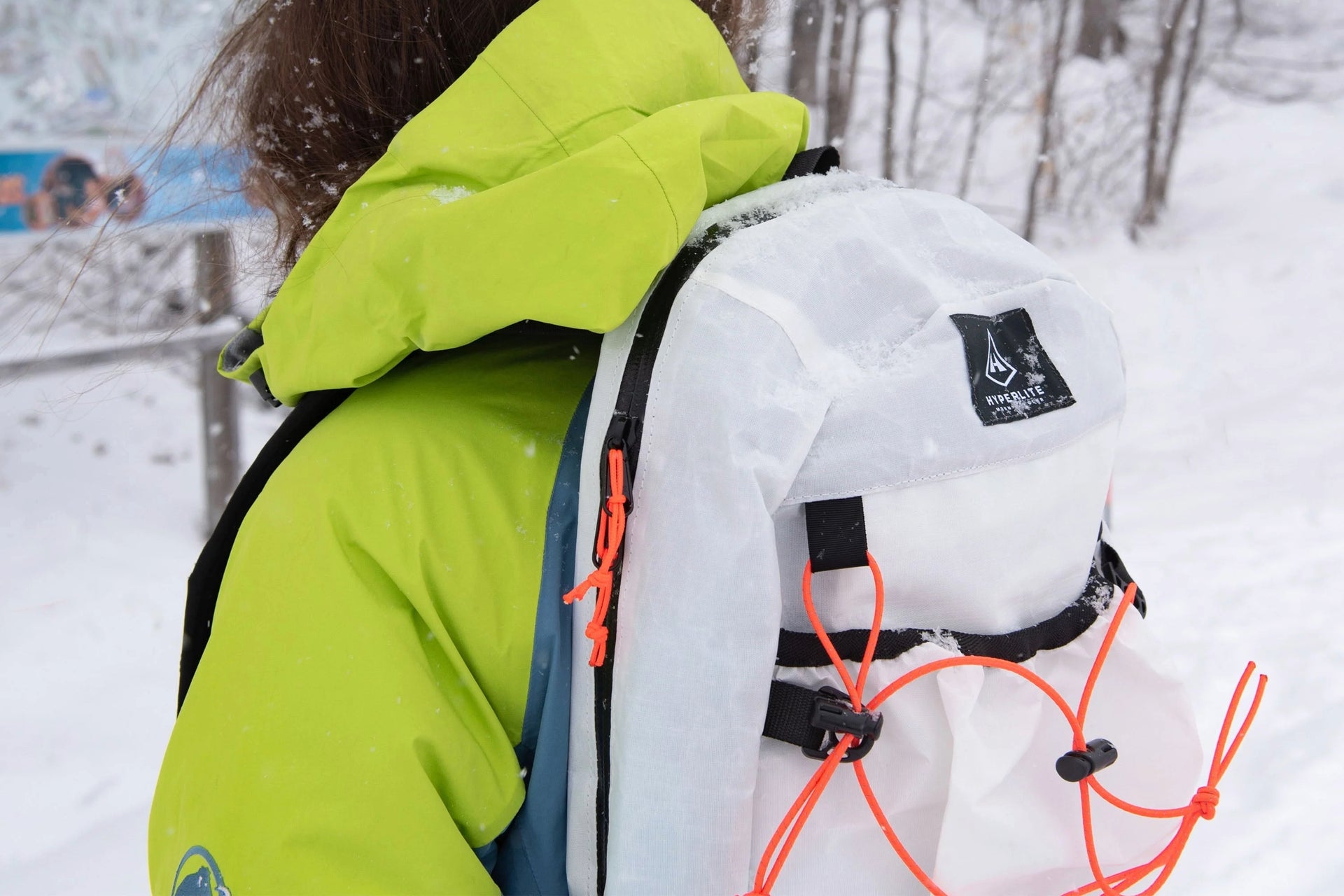 A woman wearing a white backpack in the snow.