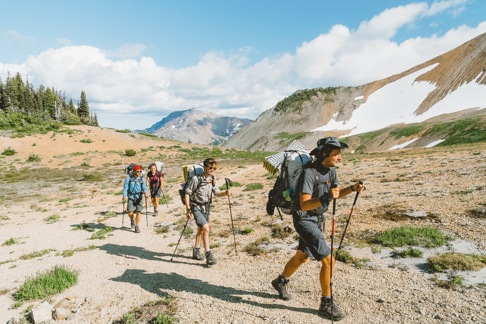 A group of hikers on a trail in the mountains.