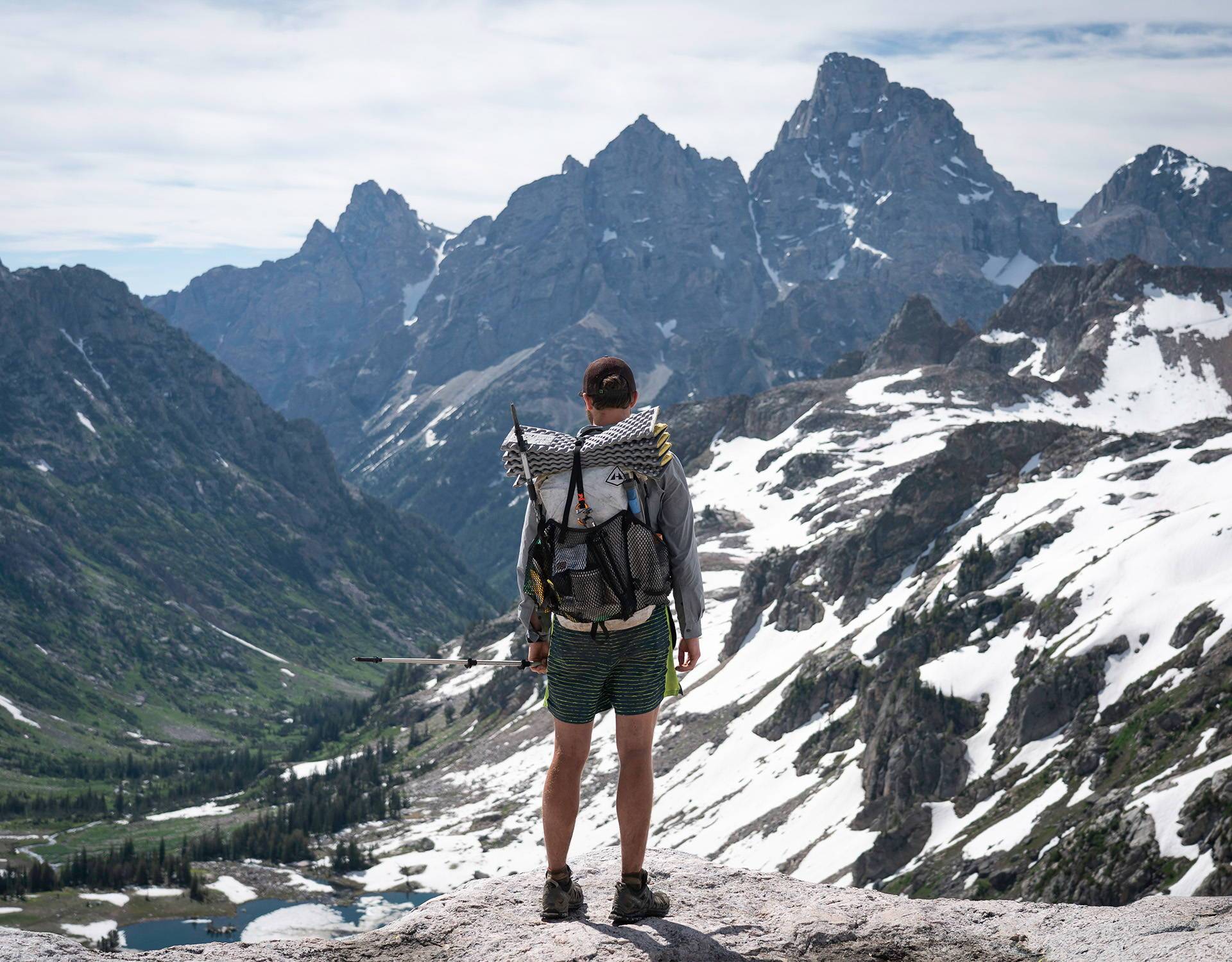 A man with a backpack standing on top of a mountain.