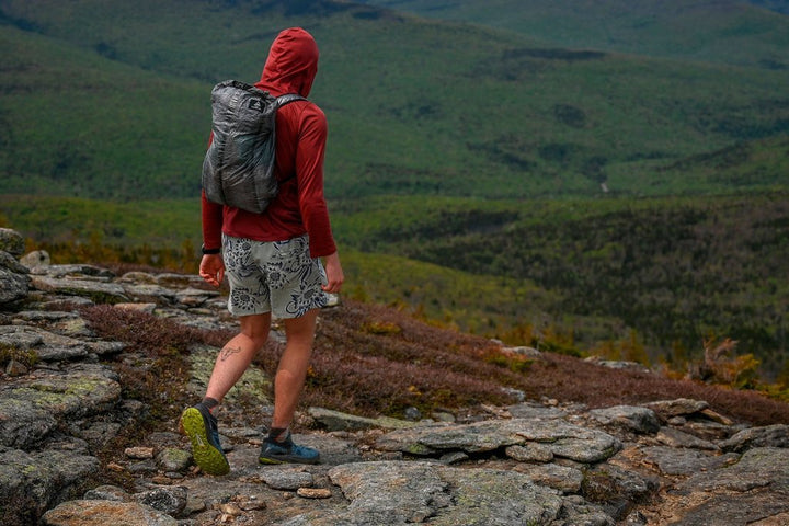 A man hiking on a rocky trail with a backpack.