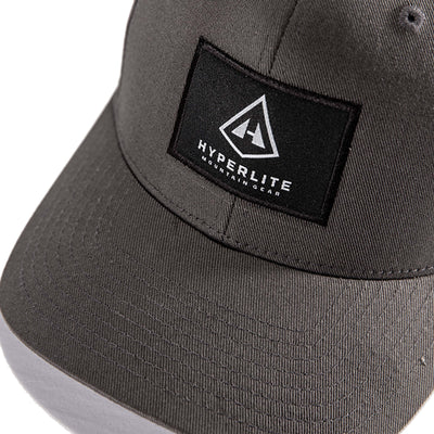 Detail shot of the Hyperlite Mountain Gear Logo on the Full Dome Hat in Dark Gray