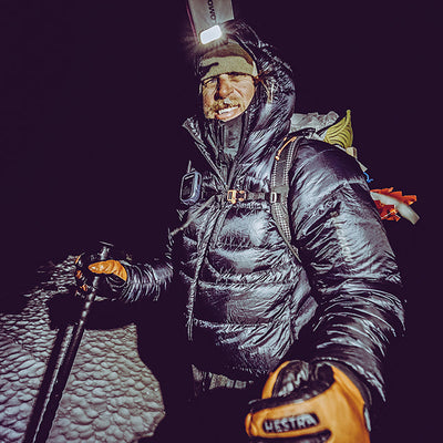 Skiier wearing a headlamp at night in the snowy terrain with the Hyperlite Mountain Gear Crux 40