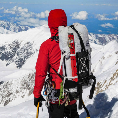 Hiker wearing Hyperlite Mountain Gear's Ice Pack 55 Pack on snowy mountain