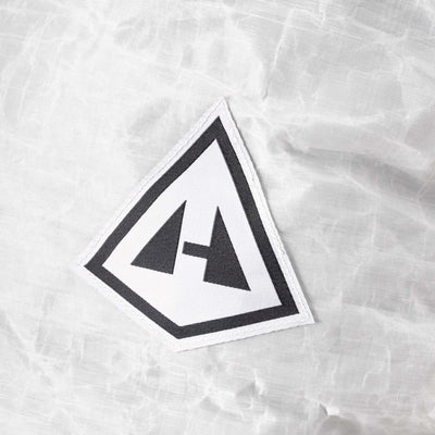 Close up of the Hyperlite Mountain Gear Badge Logo on the Dyneema® 50-denier DCH fabric of the Junction 40 in White