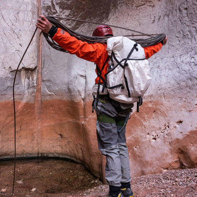 Hiker with rope wearing Hyperlite Mountain Gear's NorthRim 70 Pack in White