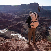 Hiker standing on mountain wearing Hyperlite Mountain Gear's NorthRim 70 Pack in White