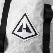Detail shot of the Hyperlite Mountain Gear Logo on the front of the Porter 40 Pack in White