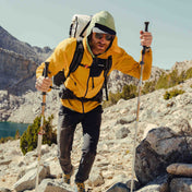 Hiker wearing the Hyperlite Mountain Gear Unbound 40 Pack with trekking poles traverses the rocky ground