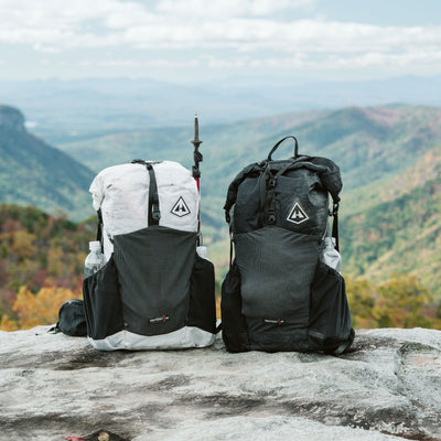 A black and white Hyperlite Mountain Gear Waypoint 35 sitting on a mountaintop overlooking a valley