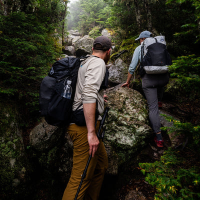 Two hikers ascend a rocky trail wearing their Hyperlite Mountain Gear Waypoint 35's