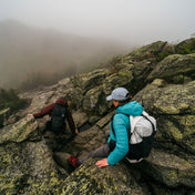 Hikers using the Hyperlite Mountain Gear Waypoint 35 descend steep and rocky terrain in the fog