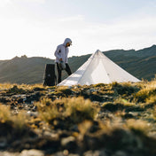A hiker walking around camp as they set up their Hyperlite Mountain Gear Mid 1 Tent