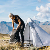 A hiker packs up their ultralight pack outside of the Hyperlite Mountain Gear Mid 1
