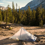 The Hyperlite Mountain Gear Mid 1 Tarp pitched out among the trees