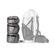 Three different sizes of the Hyperlite Mountain Gear Pods placed next to a pack for a size comparison