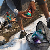 A camper uses one of the Hyperlite Mountain Gear Pods filled with snow to keep beverages chill