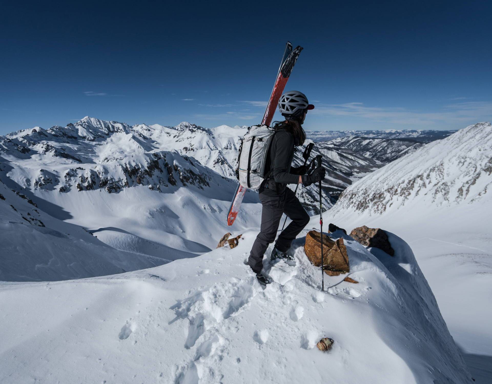 A skier standing on top of a snow covered mountain.