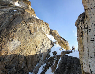 A man is climbing up a rocky cliff.