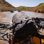 Hyperlite Mountain Gear's Porter 40 Pack in Black on top of a kayak in a river
