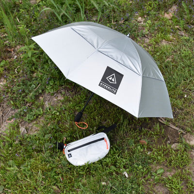 The Hyperlite Mountain Gear Versa and Essential Umbrella laying on the grass, both a part of the Runabout Bundle