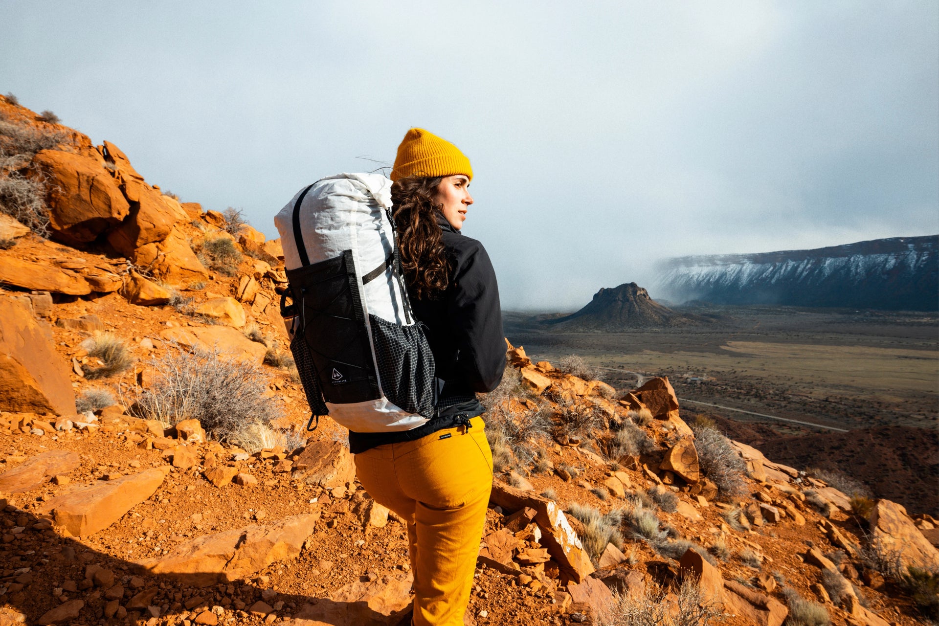 A woman with a backpack on a rocky trail.