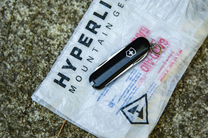 A swiss army knife sitting on top of a plastic bag.