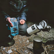At night time a hiker using the Hyperlite Mountain Gear Insulator while prepping their camp meal