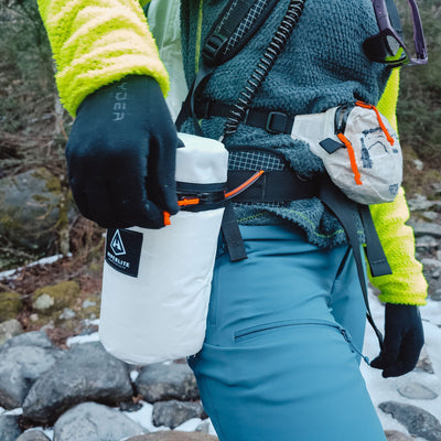 A hiker in winter gear with the Hyperlite Mountain Gear Insulator attached to their harness