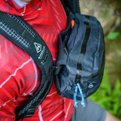 Top view of a hiker wearing Hyperlite Mountain Gear's Versa in black strapped to the backpack