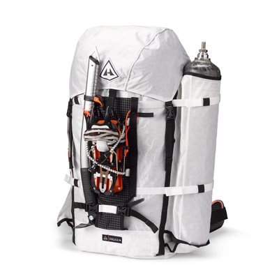 Front view of a Halka 70 by Hyperlite Mountain Gear fully packed with an ice tool, crampons, and an oxygen bottle