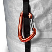 Detail shot of a carabener clipped into the side strap of Hyperlite Mountain Gear's Porter 40 Pack in White