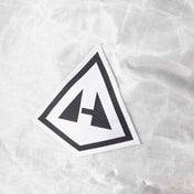 Detail of the White Southwest 55 Liter backpack's white dyneema material with a logo in a triangular shape