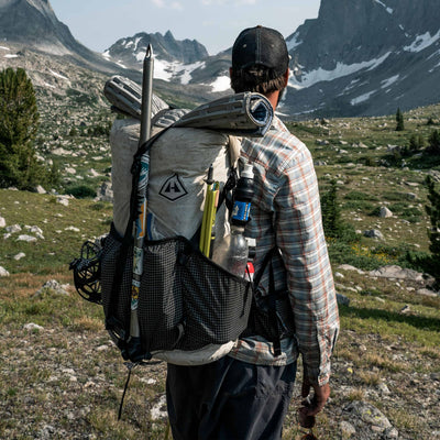 Adventurer equipped with the Southwest 55 backpack alongside a mountain