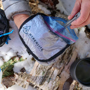 Using the Vargo Titanium Spoon a camper eats their meal out of the Hyperlite Mountain Gear REpack