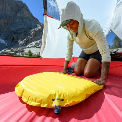 Camper rolling up Hyperlite Mountain Gear's Therm-a-Rest NeoAir® XLite™ NXT Sleeping Pad