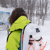 Back view of Hyperlite Mountain Gear's Daybreak 17 Pack in White on hiker in the snowy woods