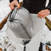 Hiker placing their Hyperlite Mountain Gear Side Entry Pod into their pack