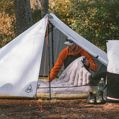 Camper in a tent laying out the Hyperlite Mountain Gear 20 Degree Quilt