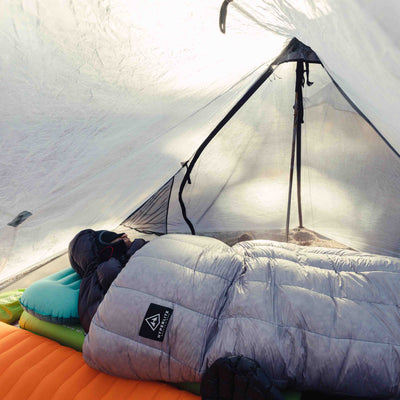 View from inside the tent as a camper sleeps in the Hyperlite Mountain Gear 20 Degree Quilt