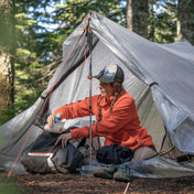 Ultralight Hiker stashing gear in their pack while inside the Hyperlite Mountain Gear Unbound 2P