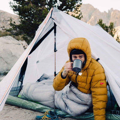 Bundled up camper enjoys some warm tea in the Hyperlite Mountain Gear Unbound 2P Tent