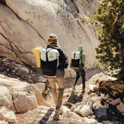 Two hikers descend the rocky desert terrain in their Hyperlite Mountain Gear Unbound 40 Packs